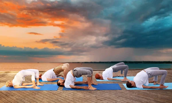 Grupo de pessoas fazendo exercícios de ioga ao ar livre — Fotografia de Stock