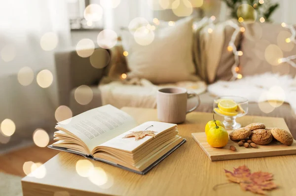 Book, lemon, tea and cookies on table at home — Stock Photo, Image