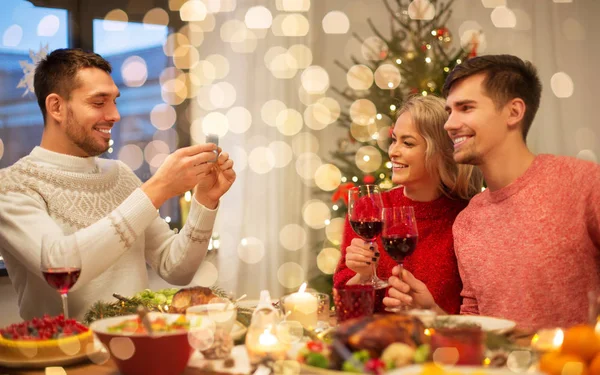 Glada vänner fotografering på julbord — Stockfoto
