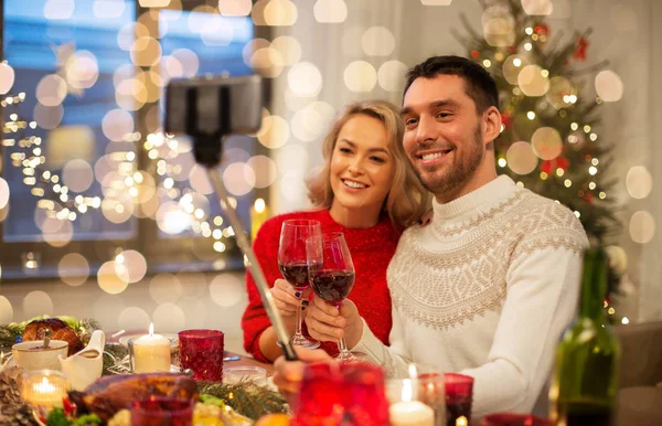 Пара фотографирует с помощью селфи-палочки на Рождество — стоковое фото