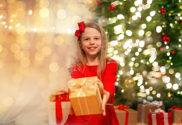 Leende flicka med julklapp hemma — Stockfoto