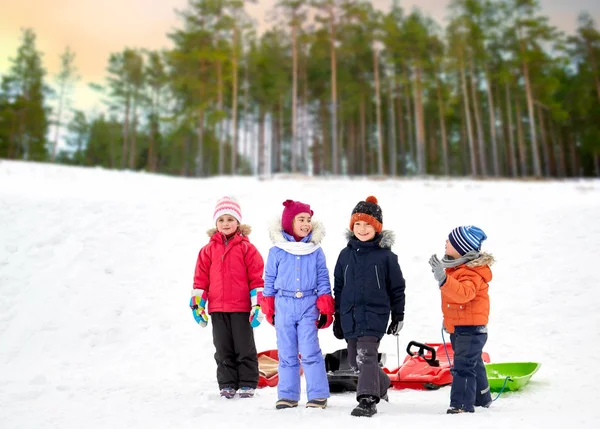 Crianças pequenas felizes com trenós no inverno — Fotografia de Stock