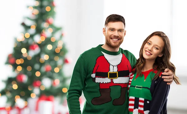 Felice coppia in brutti maglioni sopra l'albero di Natale — Foto Stock