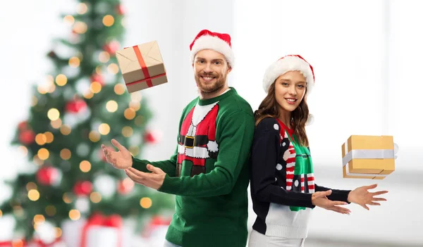 Feliz pareja en suéteres con regalos de Navidad — Foto de Stock