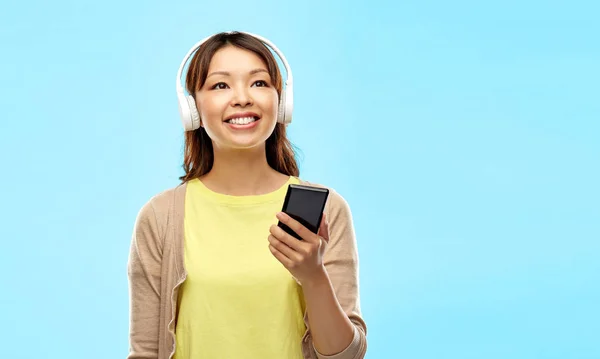 Mujer asiática en auriculares escuchando música — Foto de Stock