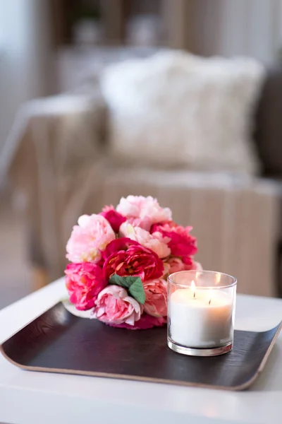 Burning fragrance candle and flower bunch at home — Stock Photo, Image