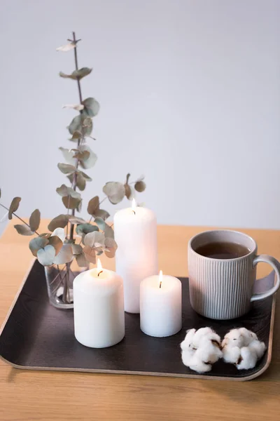 Velas, chá e ramos de eucalipto na mesa — Fotografia de Stock