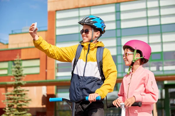 Gelukkige schoolkinderen met scooters die selfie maken — Stockfoto