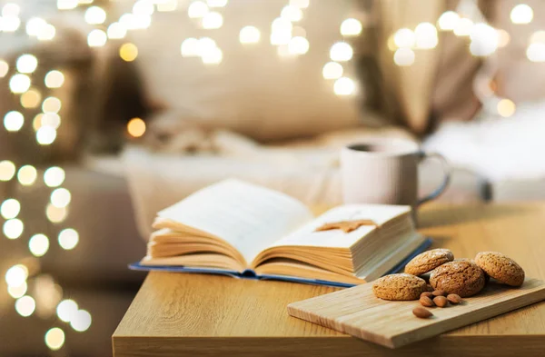 Havreflarn, mandel och boken på bordet hemma — Stockfoto