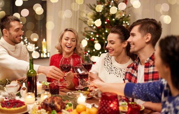 Amigos celebrando la Navidad y bebiendo vino — Foto de Stock
