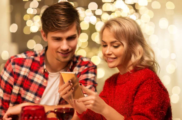 Casal com smartphone em casa jantar de Natal — Fotografia de Stock