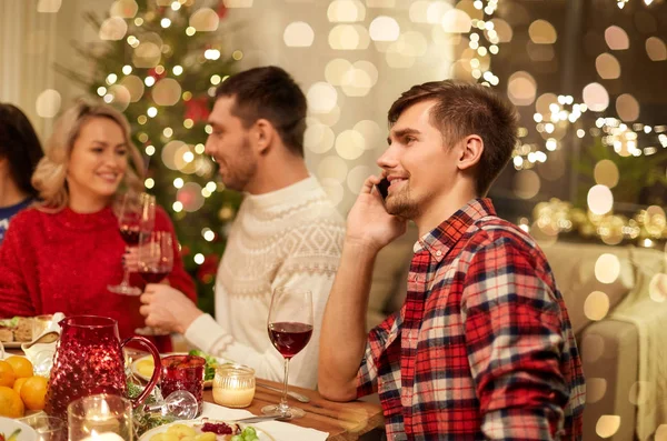 Mann telefoniert beim Weihnachtsessen mit Smartphone — Stockfoto