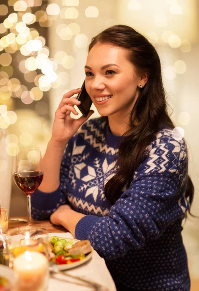 Woman calling on smartphone at christmas dinner — Stock Photo, Image