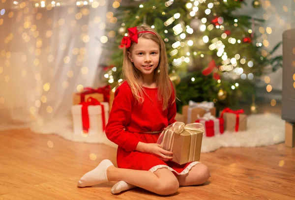 Fille souriante avec cadeau de Noël à la maison — Photo