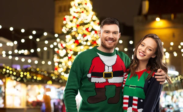 Счастливая пара в уродливых свитерах на рождественском рынке — стоковое фото