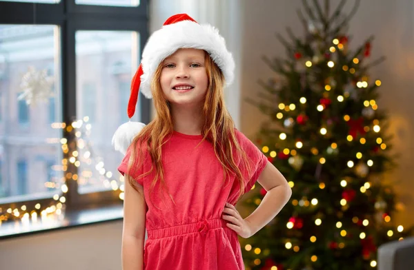 Šťastná černovlasá dívka ve svém domově pro Santa pomocný klobouk — Stock fotografie