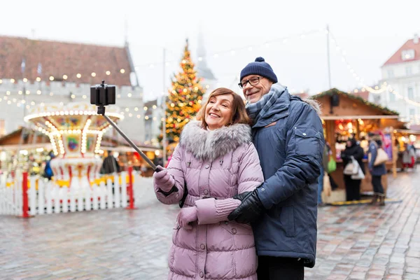 Senior paar het nemen van selfie op kerstmarkt — Stockfoto