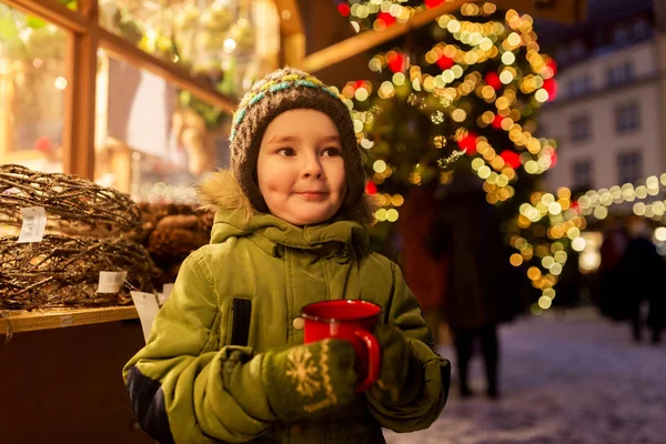 Szczęśliwy chłopiec z filiżanką herbaty na targu bożonarodzeniowy — Zdjęcie stockowe
