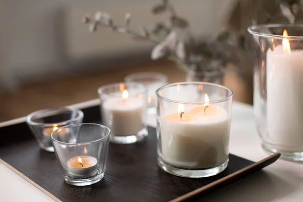 Płonące świece zapachowe na stole w przytulnym domu — Zdjęcie stockowe