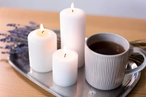 Kaarsen, thee in mok en lavendel bloemen op tafel — Stockfoto