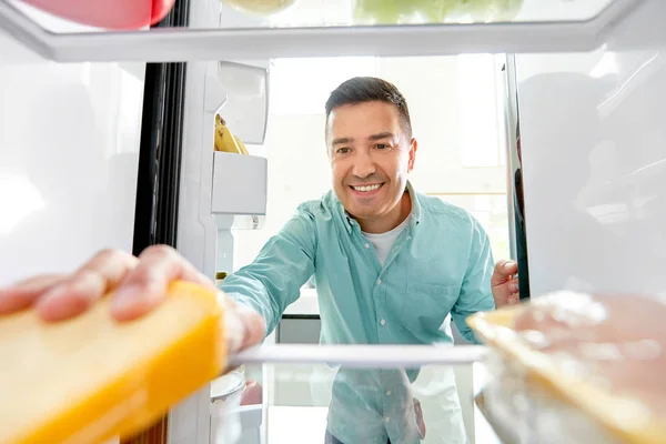 Człowiek bierze jedzenie z lodówki w kuchni — Zdjęcie stockowe