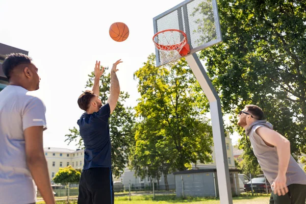 Skupina mužských přátel hrající pouliční basketbal — Stock fotografie