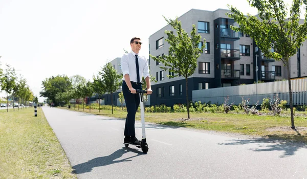 Joven hombre de negocios montar scooter eléctrico al aire libre —  Fotos de Stock