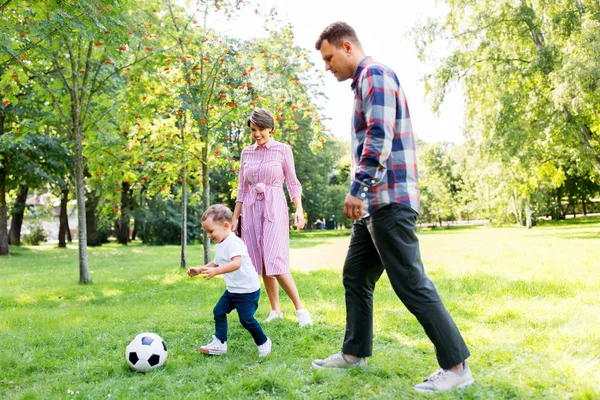 Ευτυχισμένη οικογένεια παίζοντας ποδόσφαιρο στο καλοκαιρινό πάρκο — Φωτογραφία Αρχείου