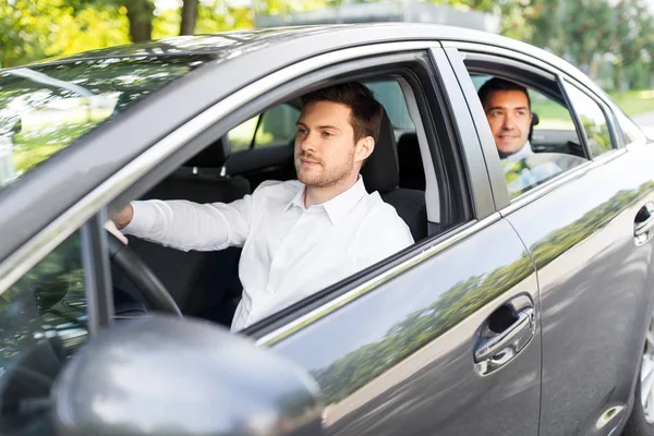 Male driver driving car with passenger — Stock Photo, Image