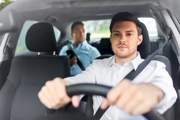 Male driver driving car with passenger Stock Image