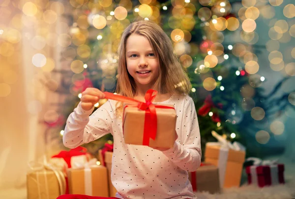 Leende flicka med julklapp hemma — Stockfoto