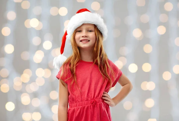 Sorridente ragazza dai capelli rossi posa in cappello Babbo Natale helper — Foto Stock