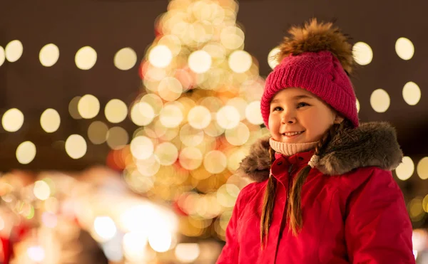 Gelukkig klein meisje op de kerstmarkt in de winter — Stockfoto