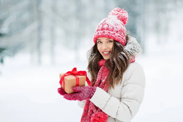 Happy young woman with christmas gift in winter — Stock Photo, Image