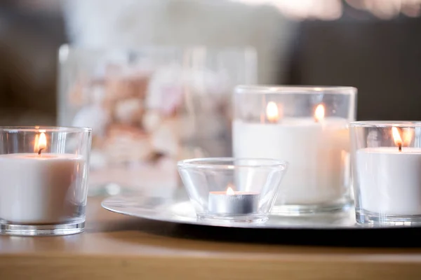 Burning white fragrance candles on tray on table — Stock Photo, Image