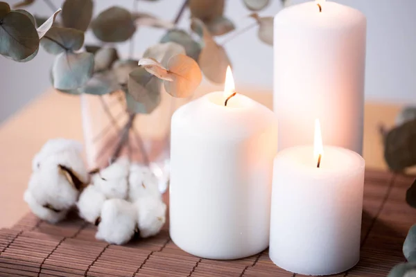 Candles and branches of eucalyptus on table — Stock Photo, Image