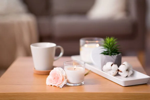 Burning candle and flower bunch on wooden table — Stock Photo, Image