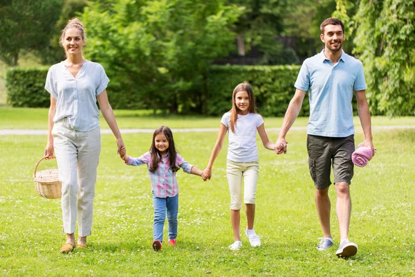 Familie met picknickmand wandelen in zomerpark — Stockfoto