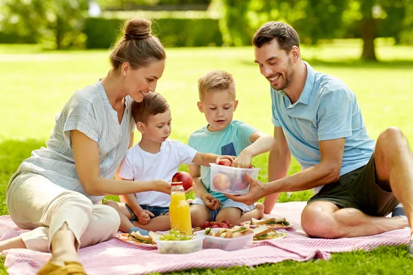 Lycklig familj som har picknick på sommarparken — Stockfoto