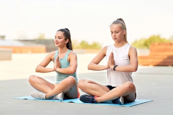 Mulheres fazendo ioga e meditando em pose de lótus — Fotografia de Stock