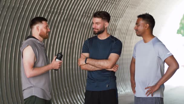 Jóvenes deportistas o amigos varones hablando al aire libre — Vídeos de Stock