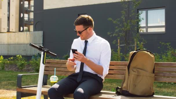 Businessman with smartphone drinking smoothie — Stock Video