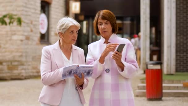 Senior kvinnor med stadsguide och smartphone — Stockvideo