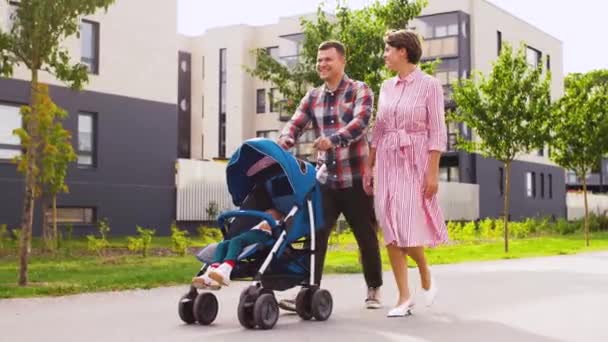 Famiglia con bimbo in passeggino passeggiando lungo la città — Video Stock