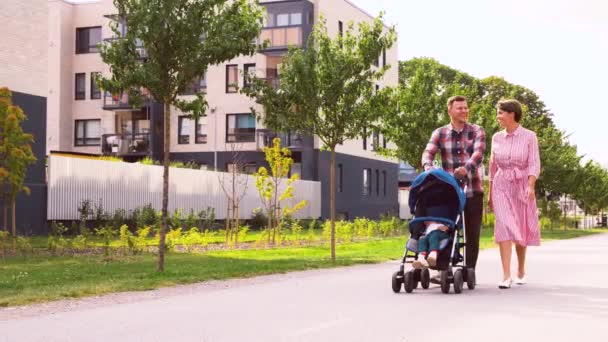 Famille avec bébé en poussette marchant le long de la ville — Video