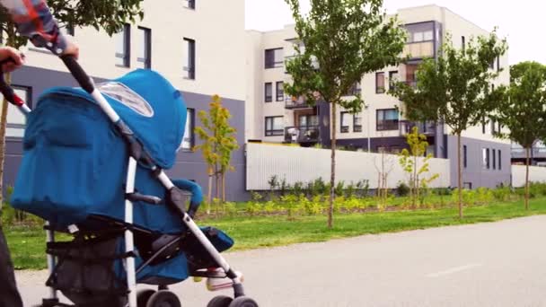 Πατέρας με το μωρό σε καροτσάκι περπάτημα κατά μήκος της πόλης — Αρχείο Βίντεο