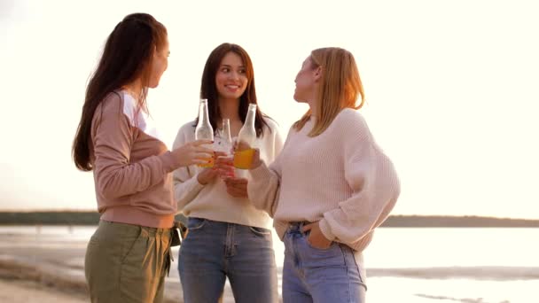Mujeres jóvenes brindando bebidas no alcohólicas en la playa — Vídeo de stock