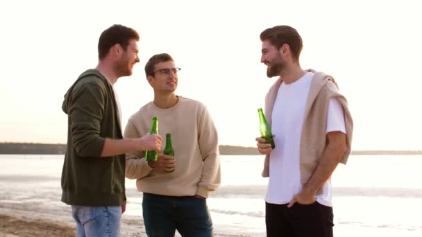 Молодые люди пьют безалкогольное пиво на пляже — стоковое видео
