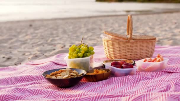 Питание и корзина для пикника на одеяле на пляже — стоковое видео