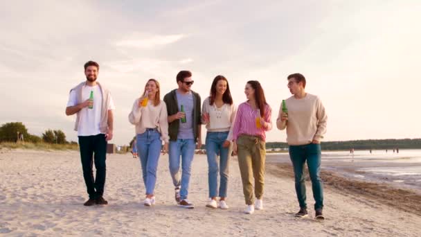 Amigos com bebidas não alcoólicas andando na praia — Vídeo de Stock